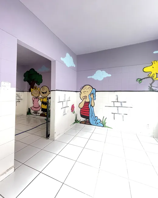 Quarto da hospedagem com mural do Charlie Brown e piso claro
